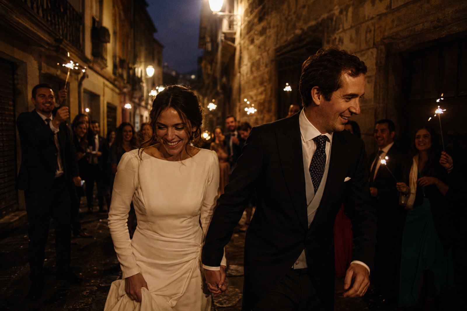 Pareja de recién casados caminando por una calle de Madrid al atardecer